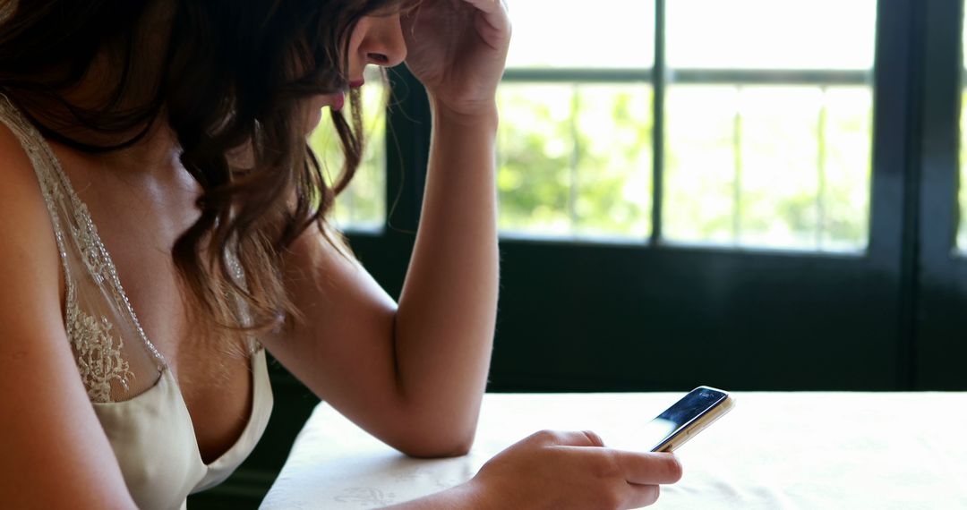 Woman Texting on Smartphone in Sunny Café Near Window - Free Images, Stock Photos and Pictures on Pikwizard.com