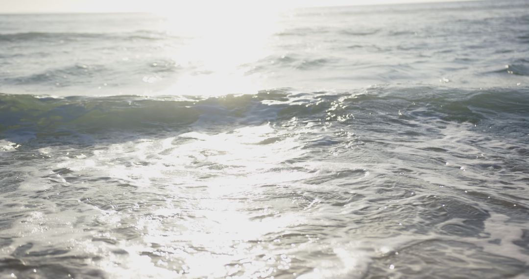 Sunlight Reflections on Gentle Sea Waves at Tranquil Beach