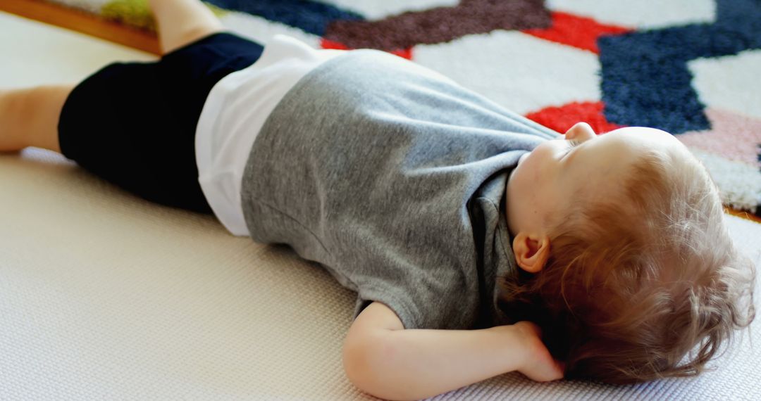 Toddler Lying on Carpet Relaxing at Home - Free Images, Stock Photos and Pictures on Pikwizard.com