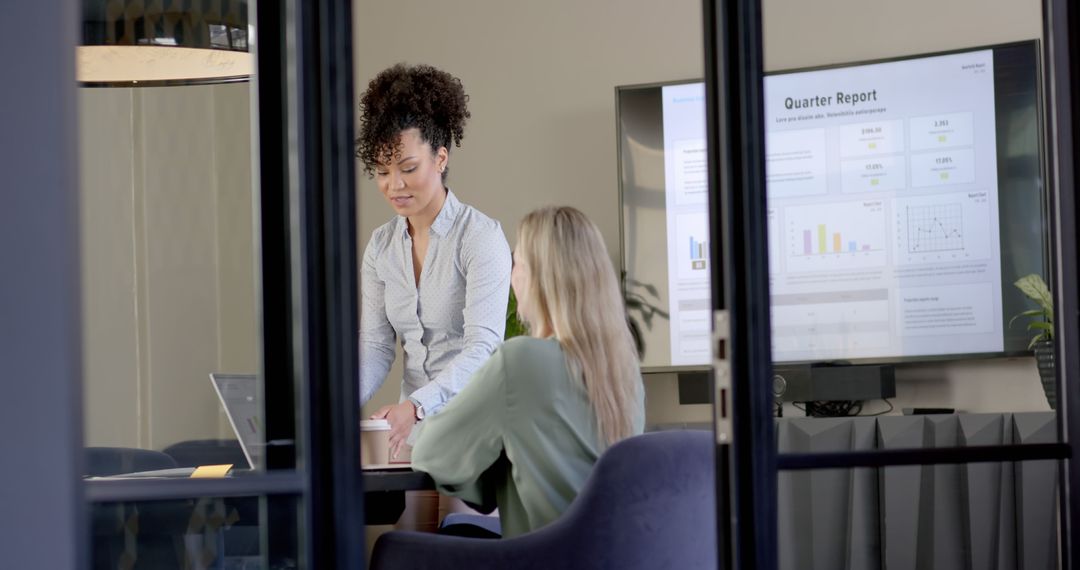 Businesswomen Discussing Quarterly Report in Modern Office - Free Images, Stock Photos and Pictures on Pikwizard.com