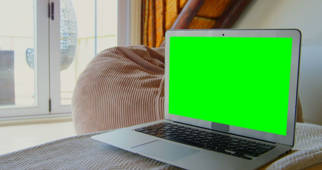 Laptop with Green Screen on Table in Cozy Home Environment - Free Images, Stock Photos and Pictures on Pikwizard.com