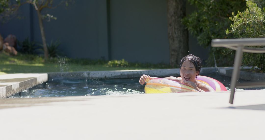 Person Enjoying Sunshine on Pool Float in Tranquil Backyard