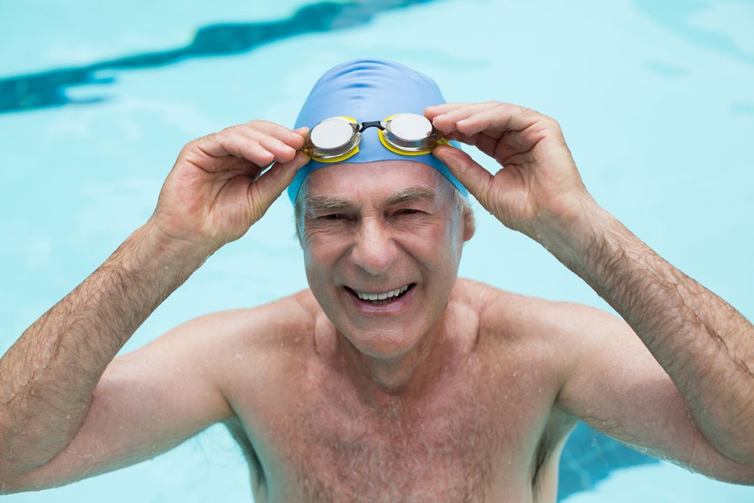 Senior man holding goggles in swimming pool - Free Images, Stock Photos and Pictures on Pikwizard.com