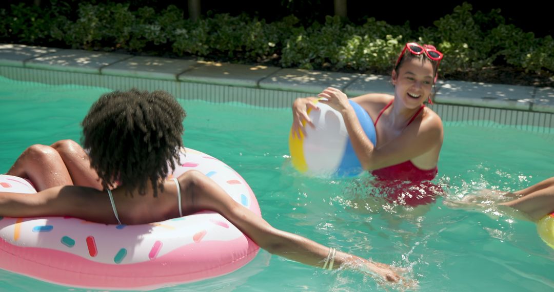 Young Women Relaxing and Enjoying Fun in Sun with Pool Floats and Beach Balls