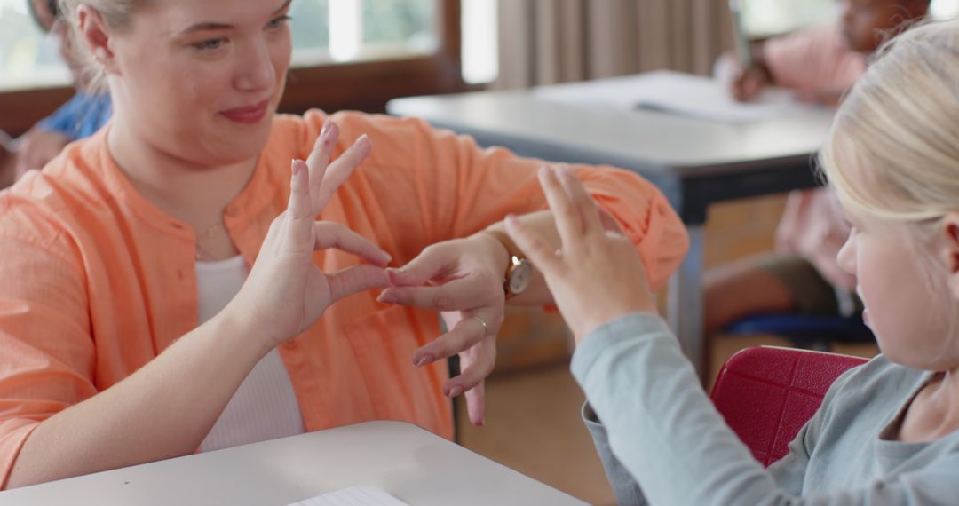 Teacher Instructing Student with Sign Language in Classroom