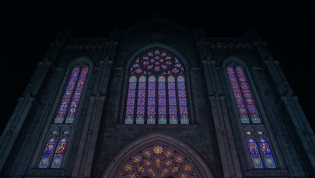 Illuminated Gothic Cathedral at Night with Stained Glass Windows