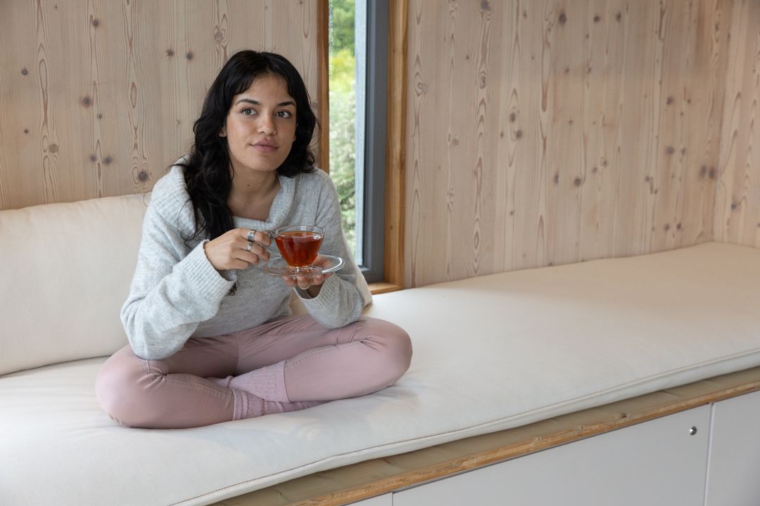Woman Relaxing at Home with Tea in Cozy Minimalist Space