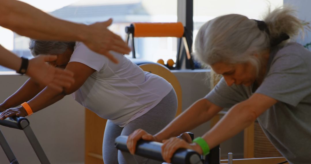 Senior Women Exercising on Pilates Equipment During Workout Session - Free Images, Stock Photos and Pictures on Pikwizard.com