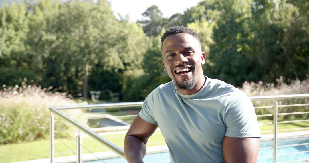 Smiling Man Relaxing by Pool on Sunny Summer Day