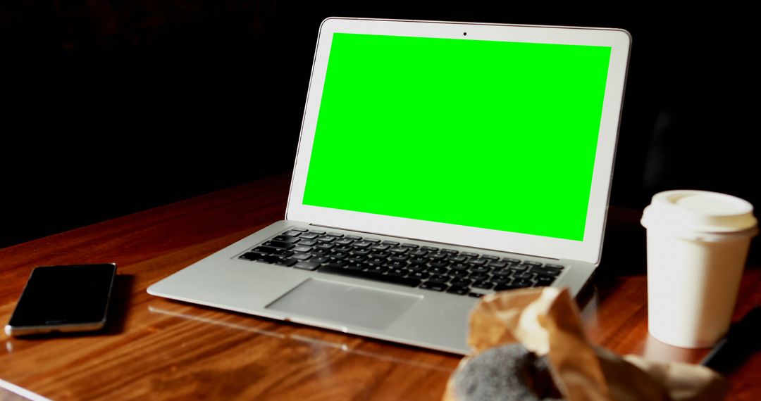 Laptop with Green Screen on Wooden Desk Next to Smartphone and Coffee Cup - Free Images, Stock Photos and Pictures on Pikwizard.com