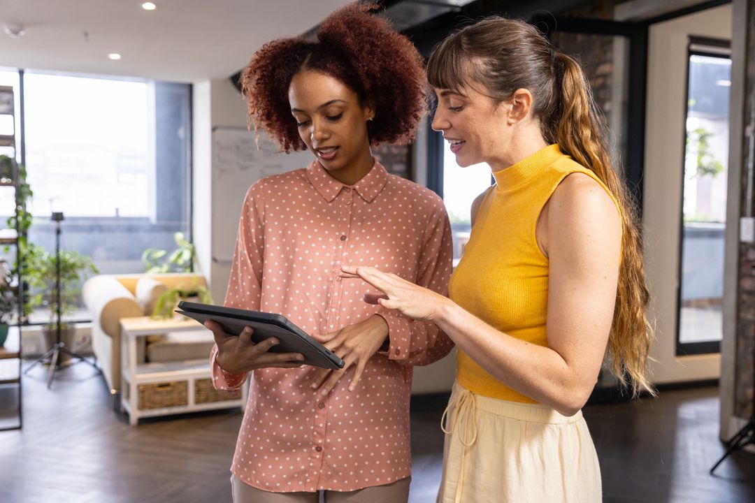 Diverse Colleagues Collaborating on Tablet in Modern Workspace