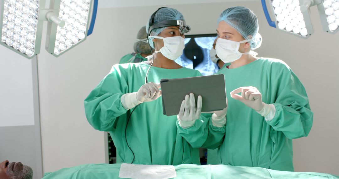 Surgeons Discussing Medical Procedure Using Digital Tablet - Free Images, Stock Photos and Pictures on Pikwizard.com