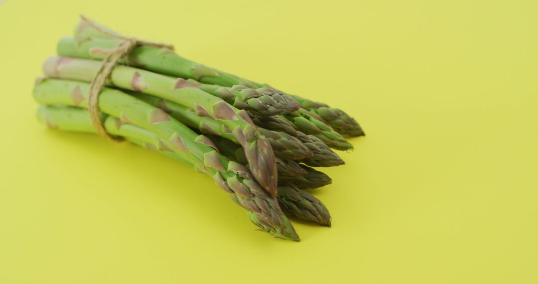 Image of close up of bundle of fresh asparagus over green background - Free Images, Stock Photos and Pictures on Pikwizard.com