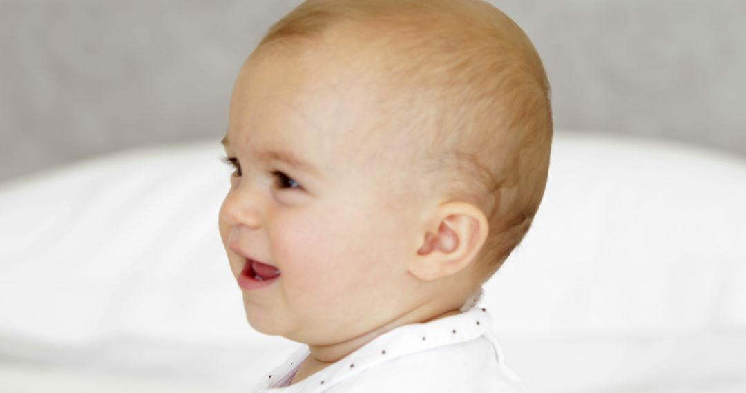 Laughing Baby Wearing White Bib Looking Away - Free Images, Stock Photos and Pictures on Pikwizard.com