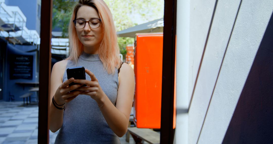 Young Woman with Pink Hair Using Smartphone Outdoors - Free Images, Stock Photos and Pictures on Pikwizard.com