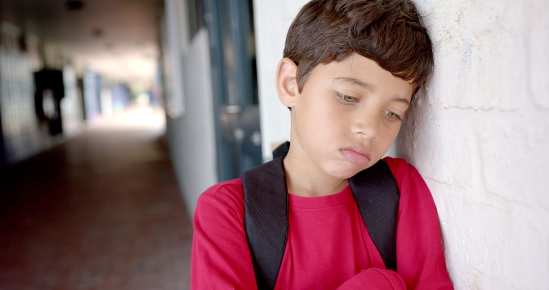 Sad Boy with Backpack at School Corridor Looking Thoughtful