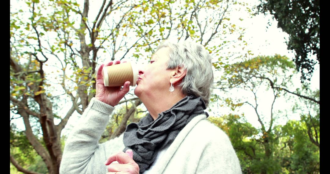 Elderly Woman Enjoying Coffee Outdoors on a Sunny Day - Free Images, Stock Photos and Pictures on Pikwizard.com