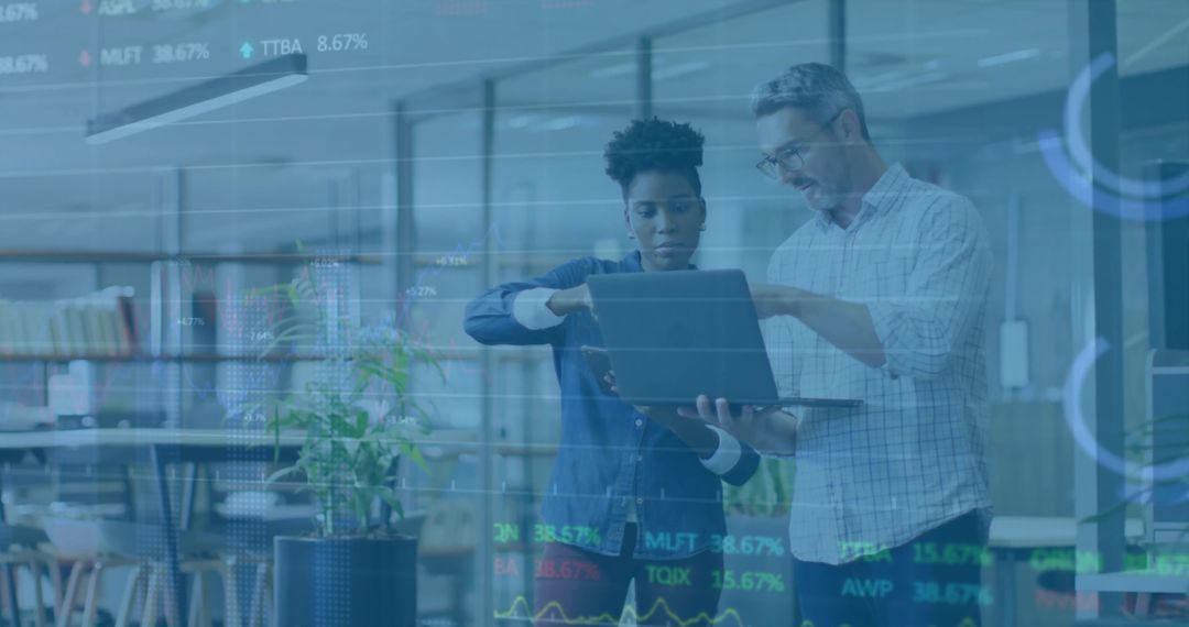 Colleagues Analyzing Stock Market Using Laptop in Modern Office Workspace