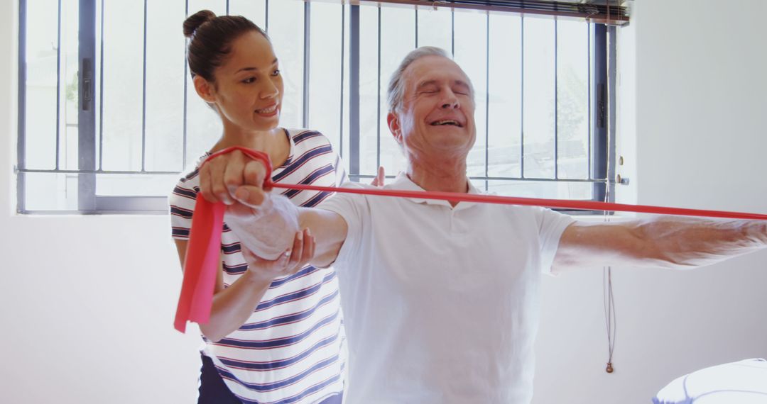 Elderly Man Exercising with Assistance from Physiotherapist - Free Images, Stock Photos and Pictures on Pikwizard.com