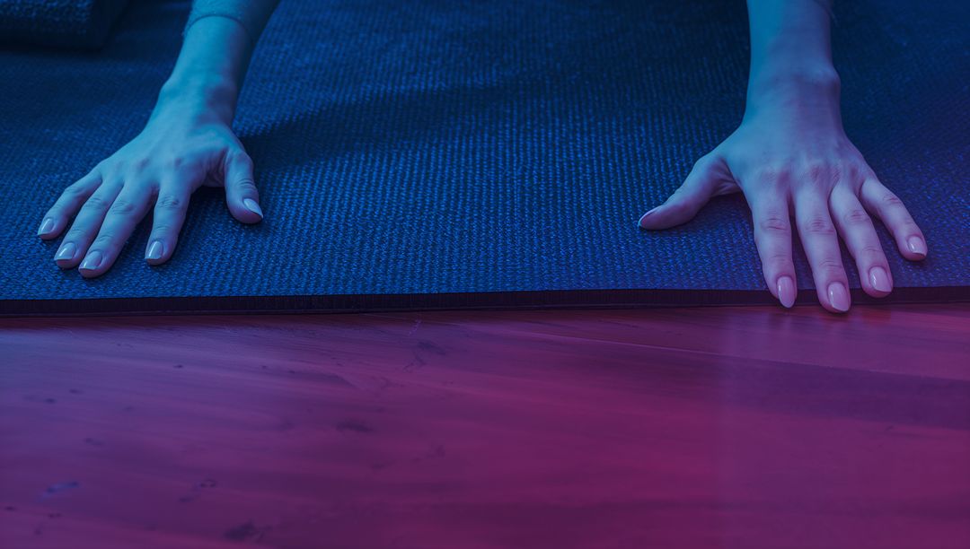 Female Hands on Yoga Mat in Ambient Lighting Reflecting Relaxation