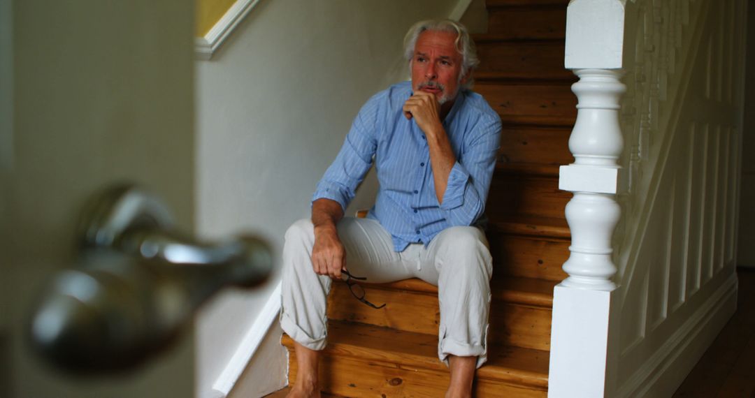 Senior Man Sitting on Wooden Stairs at Home Pondering - Free Images, Stock Photos and Pictures on Pikwizard.com