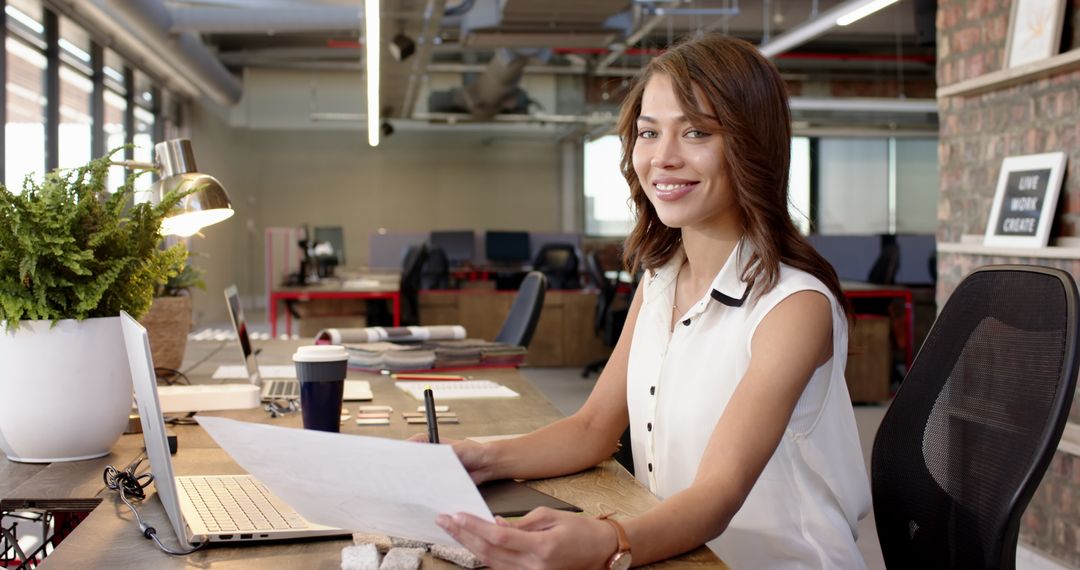 Confident Businesswoman at Modern Office Desk with Laptop