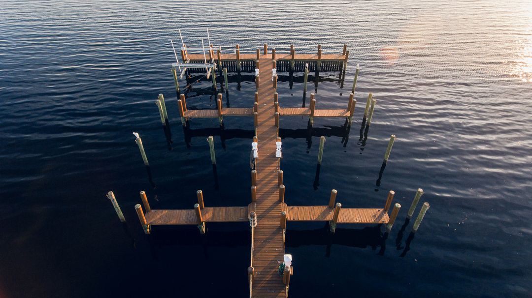 Empty Wooden Dock Extending Into Calm Water at Sunset - Free Images, Stock Photos and Pictures on Pikwizard.com