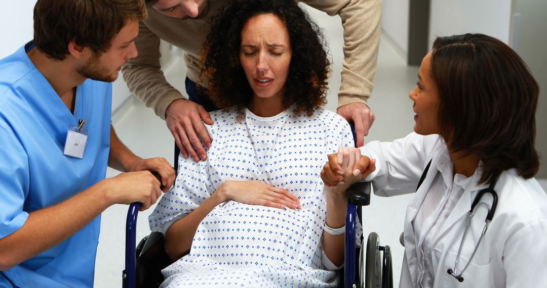 Pregnant woman being wheeled into delivery room receiving support - Free Images, Stock Photos and Pictures on Pikwizard.com