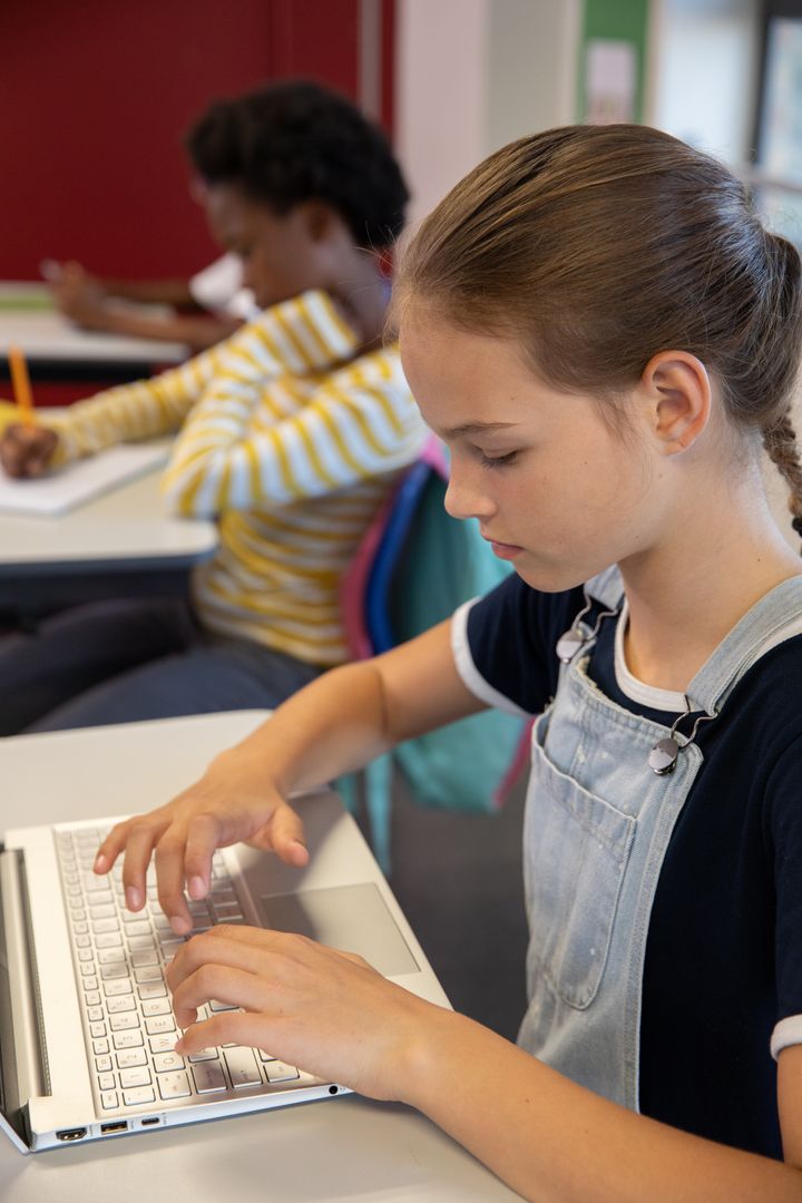 Focused Students Learning with Technology and Pen in Classroom