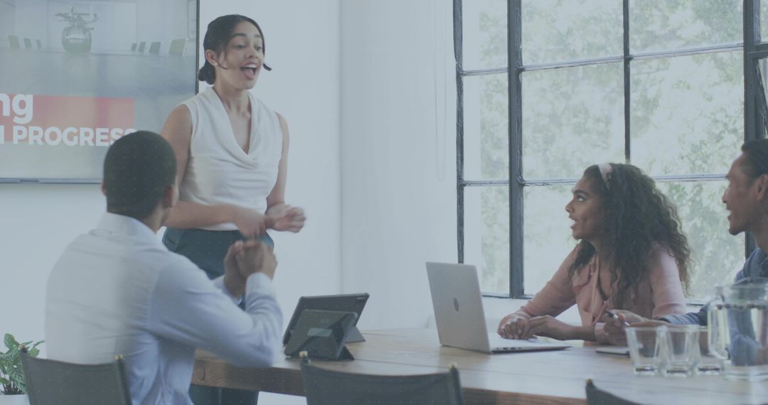 Female Presenter Leading Team Meeting in Modern Boardroom with Laptop and Collaboration