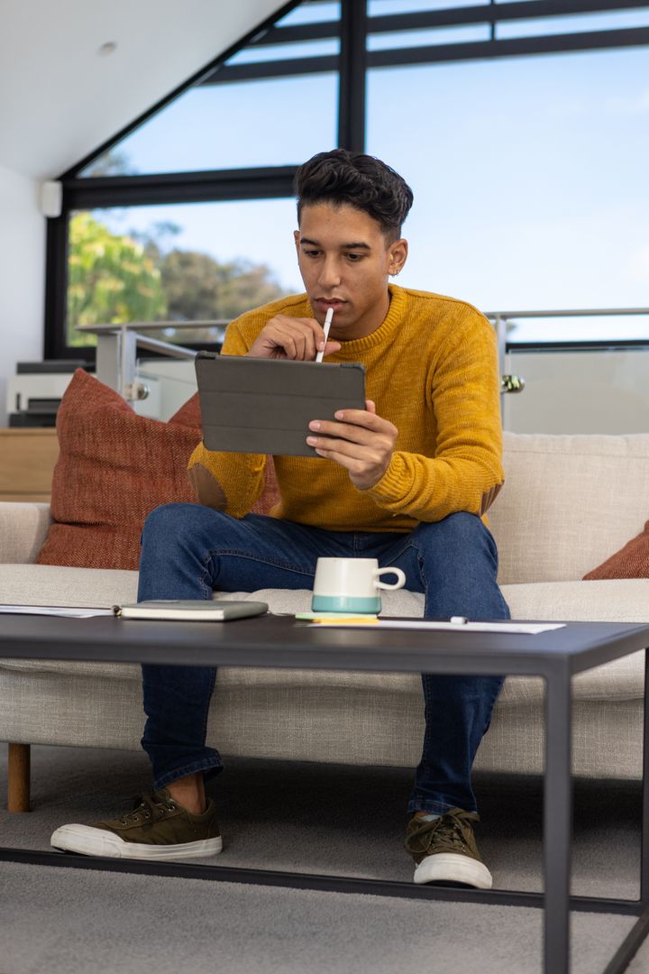 Man Using Tablet with Stylus in Modern Home Setting