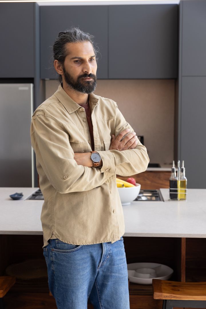 Contemplative Middle-Aged Man Standing in Modern Kitchen