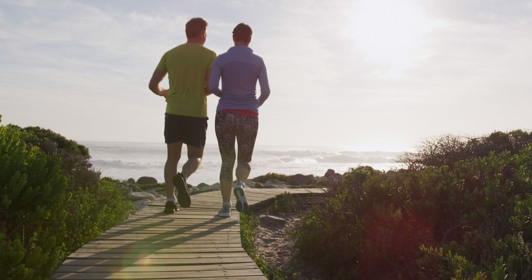 Couple Jogging on Coastal Boardwalk During Sunrise - Free Images, Stock Photos and Pictures on Pikwizard.com