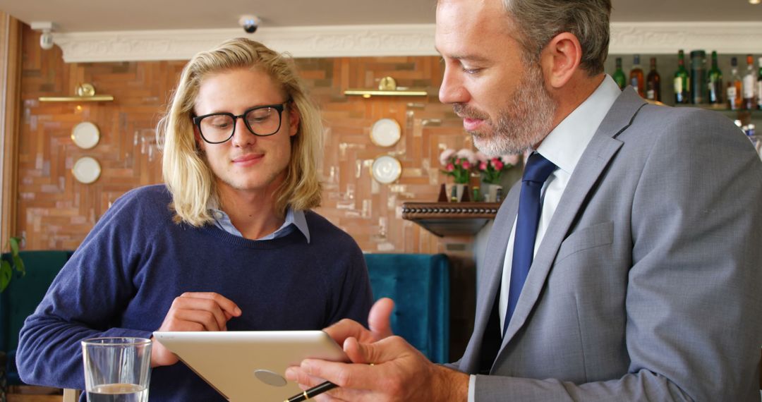 Business Professionals Collaborating in Café with Digital Tablet