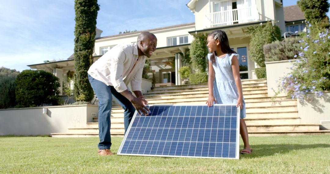 Father and Daughter Setting Up Solar Panel in Front Yard for Green Energy