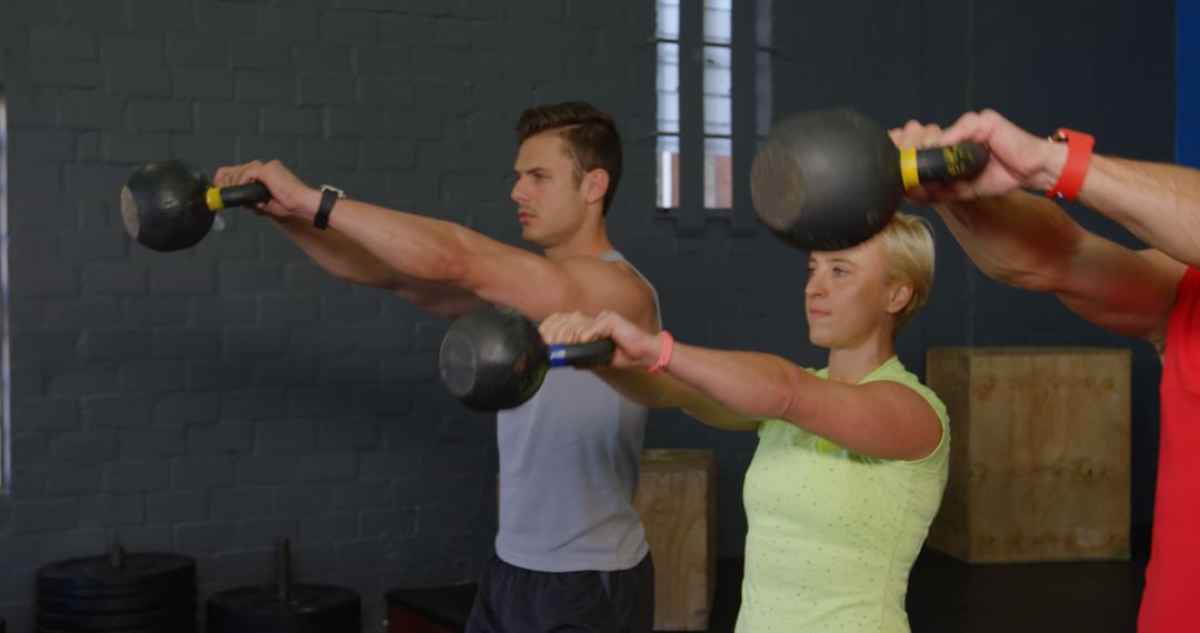 Fit Adults in Gym Doing Kettlebell Swings Together - Free Images, Stock Photos and Pictures on Pikwizard.com