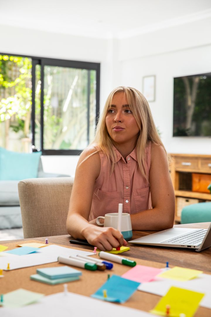 Woman Managing Tasks in Bright Home Workspace for Productivity