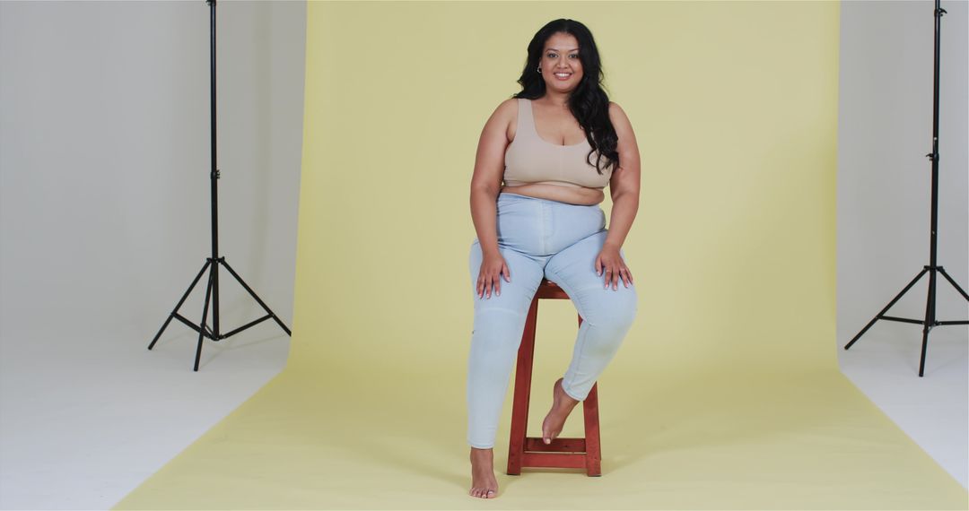 Confident Plus-Size Woman Posing Against Yellow Studio Backdrop