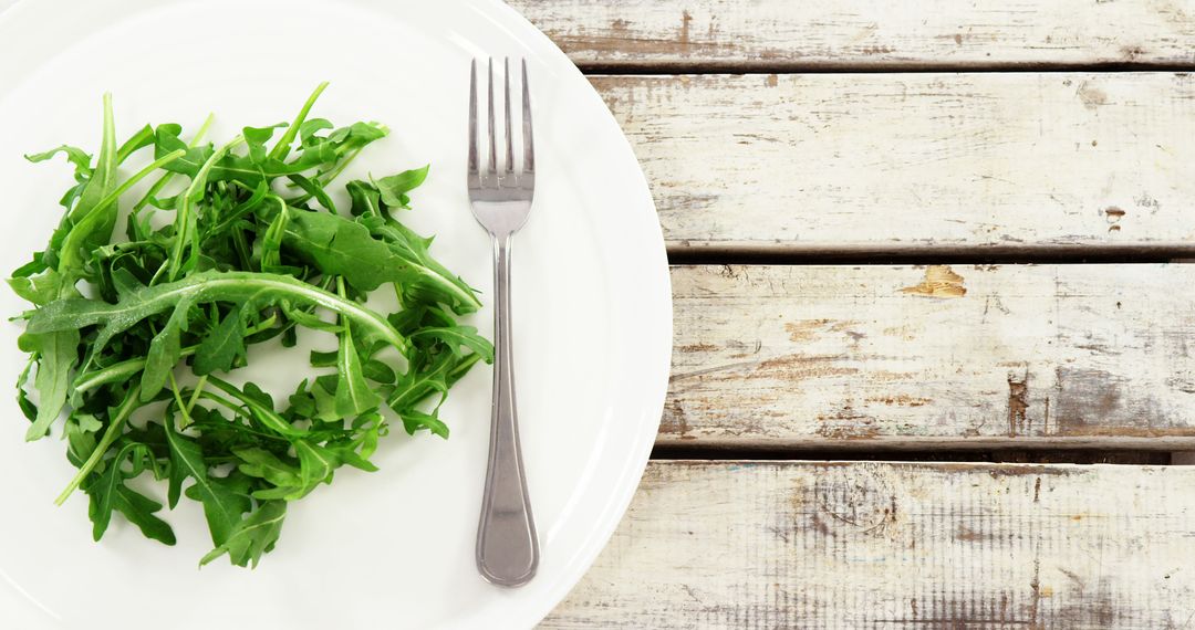 Fresh Arugula Salad Leaves on Rustic Wooden Table