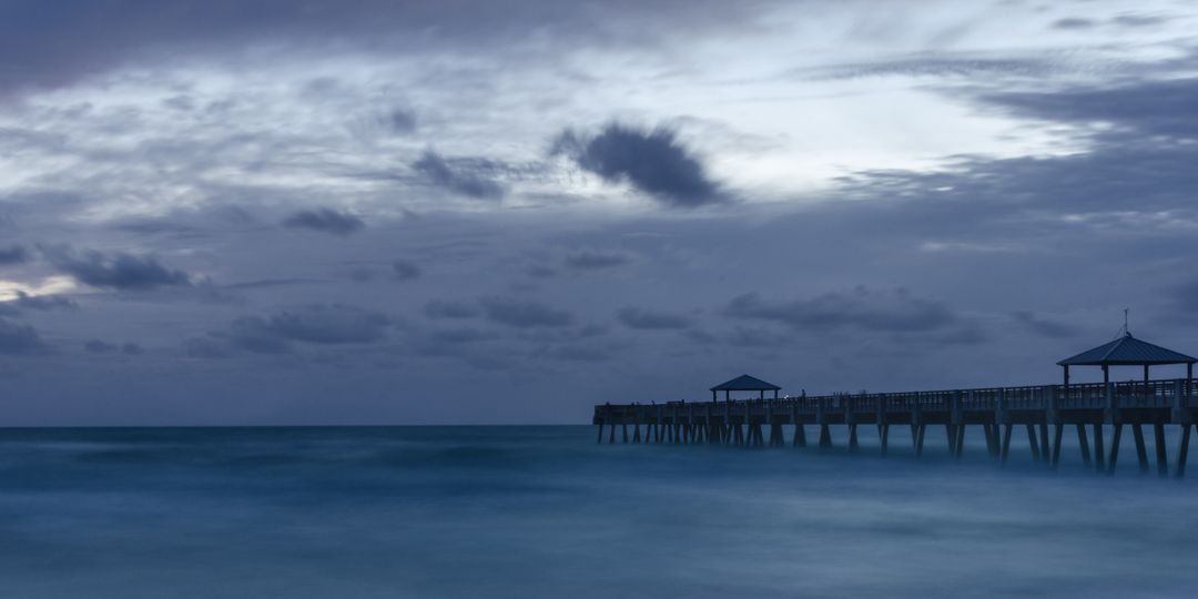 Serene Ocean Pier at Dusk with Dramatic Sky - Free Images, Stock Photos and Pictures on Pikwizard.com