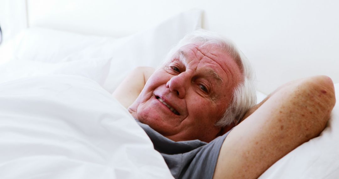 Elderly Man Smiling While Relaxing in Bed - Free Images, Stock Photos and Pictures on Pikwizard.com