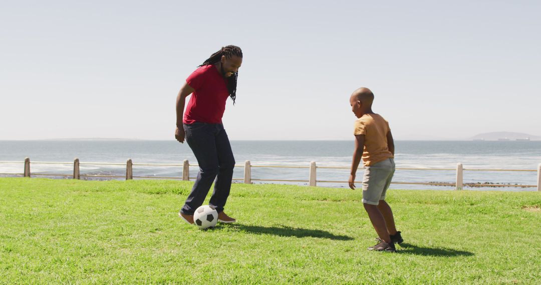 Father and Son Playing Soccer on Sunny Day by Sea - Free Images, Stock Photos and Pictures on Pikwizard.com