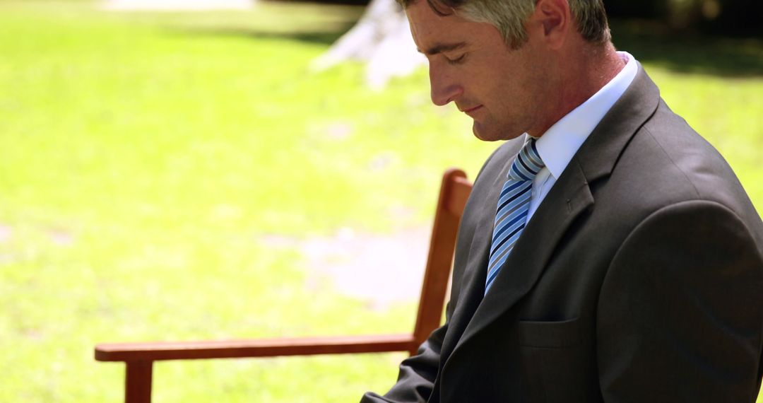 Businessman in Suit Sitting Outdoors on a Bench Working - Free Images, Stock Photos and Pictures on Pikwizard.com