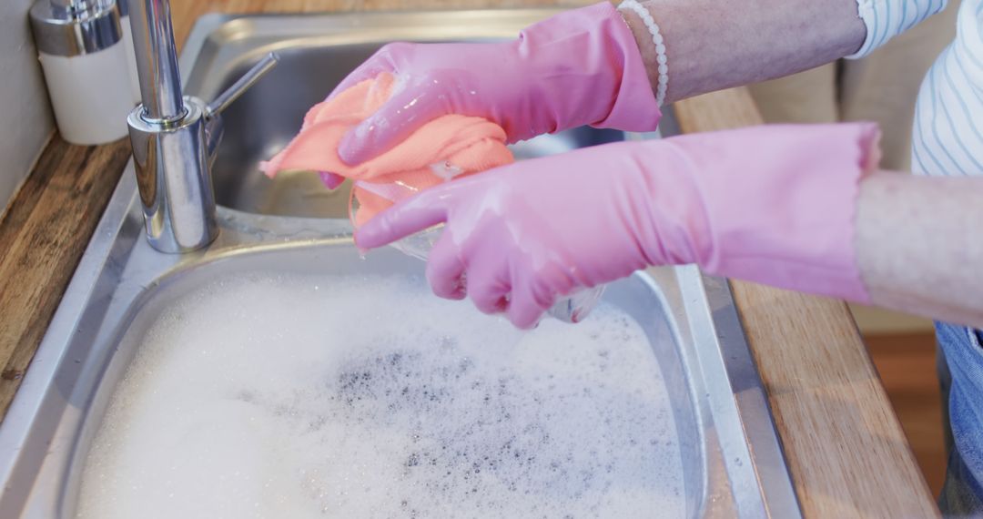 Person Washing Dishes With Pink Gloves In Soapy Sink - Free Images, Stock Photos and Pictures on Pikwizard.com