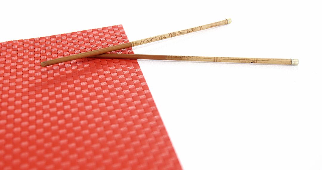 Wooden Chopsticks on Red Textured Mat Isolated on White Background - Free Images, Stock Photos and Pictures on Pikwizard.com