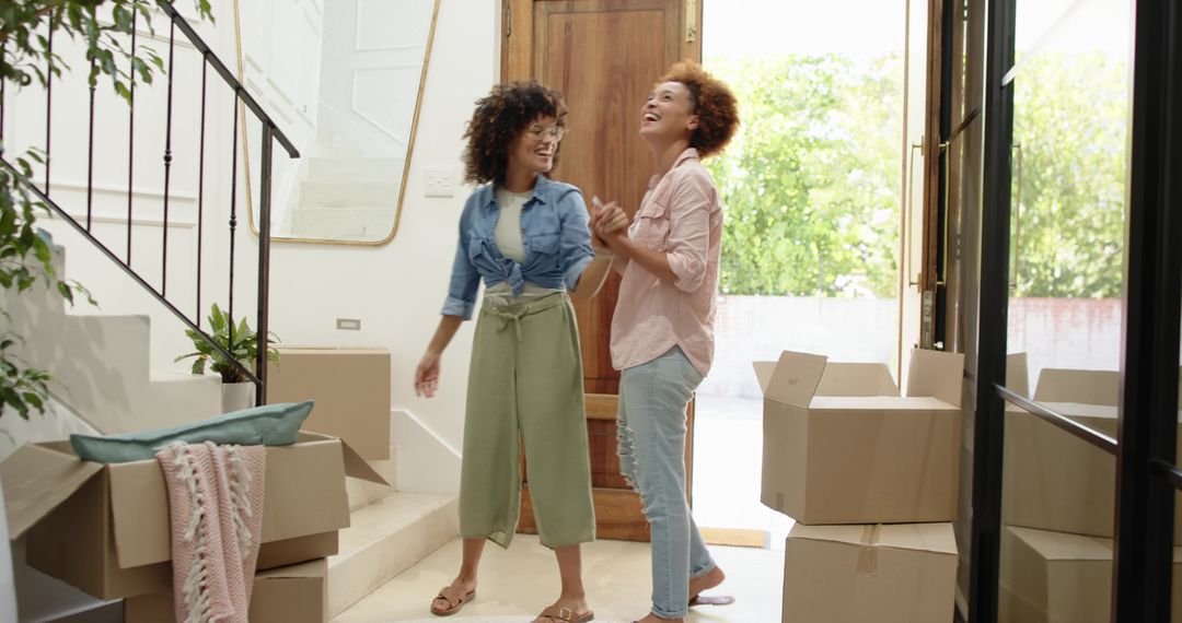 Sunlit new home arrival with friends unpacking boxes and laughing in airy entryway
