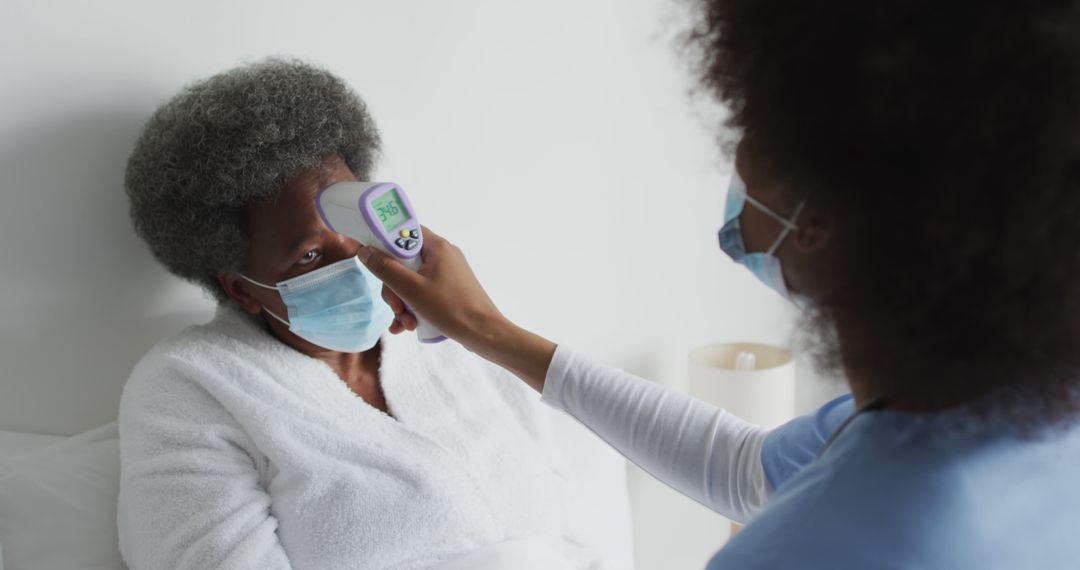 Nurse Using Infrared Thermometer on Elderly Patient in Hospital - Free Images, Stock Photos and Pictures on Pikwizard.com