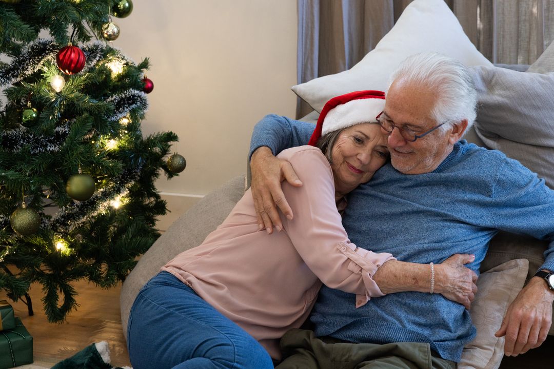 Senior Couple Embracing Near Christmas Tree in Festive Home