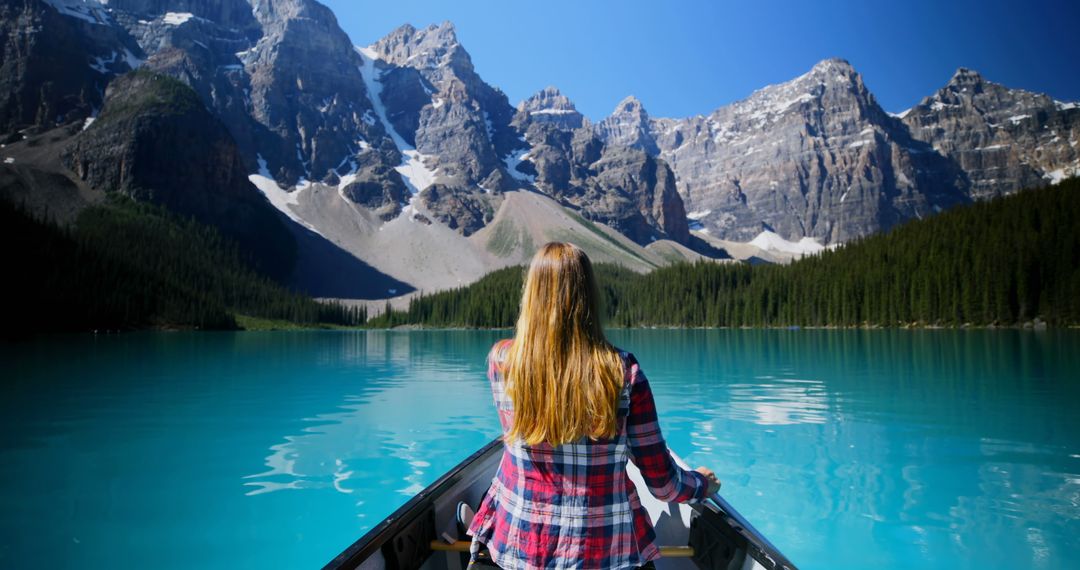 Woman Canoeing on Turquoise Mountain Lake in Rocky Mountains - Free Images, Stock Photos and Pictures on Pikwizard.com