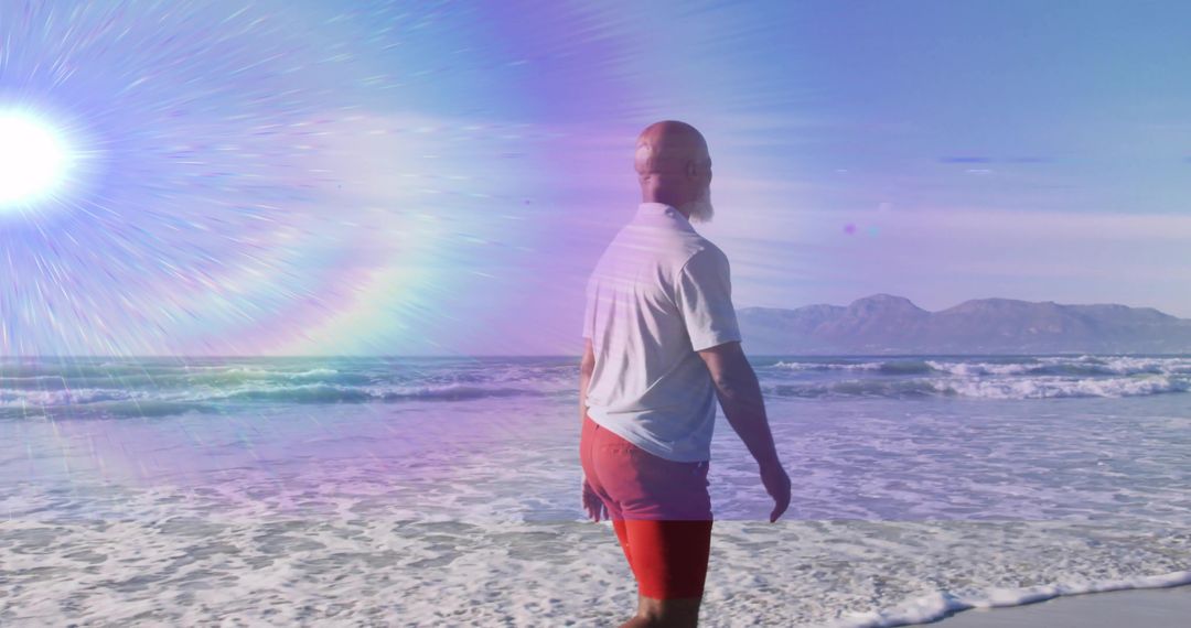 Man Strolling Beach in Sunlight Beside Ocean Waves